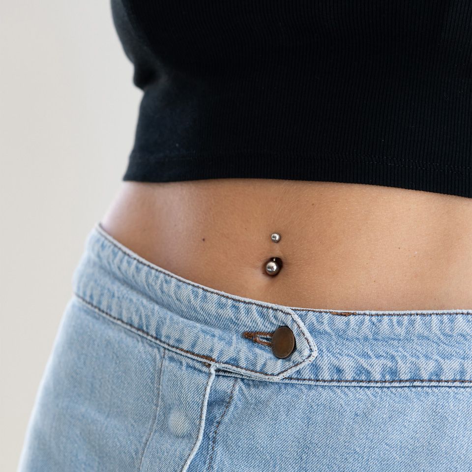 Navelpiercing av titan i olika färger