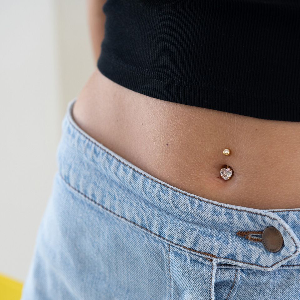 Navelpiercing i flera färger med hjärtsten