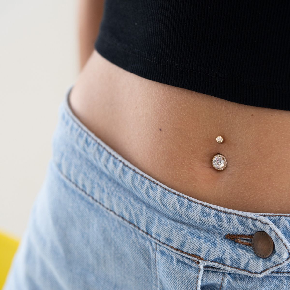 Navelpiercing med fäst mittensten