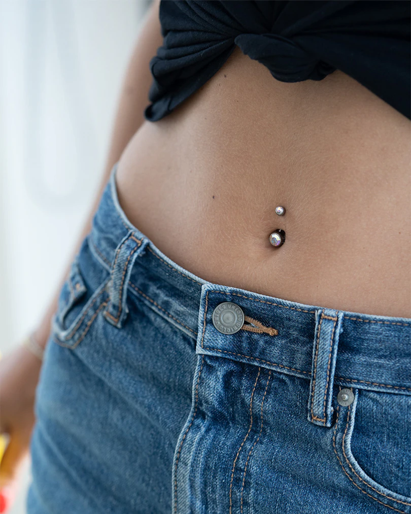Navelpiercing av titan med två stenar