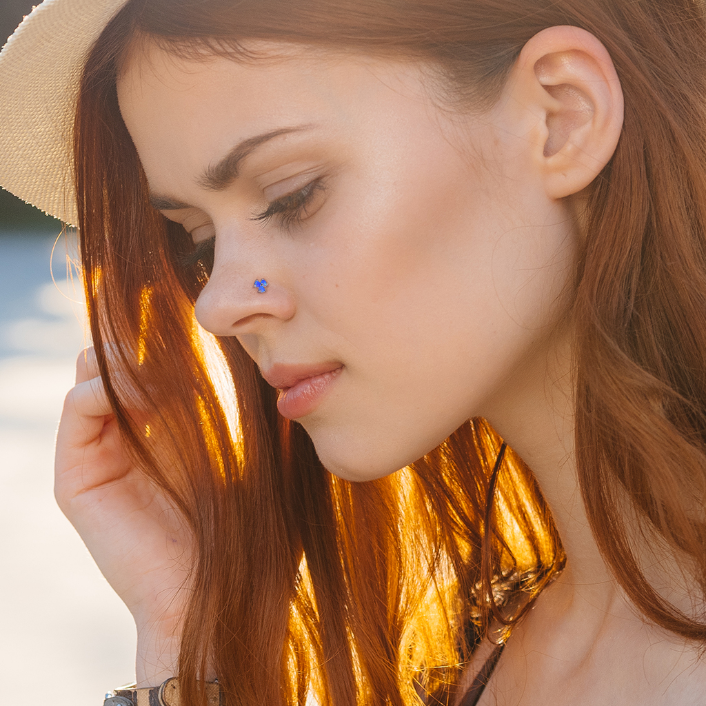 Näspiercing av 14 karat guld med tre opalstenar