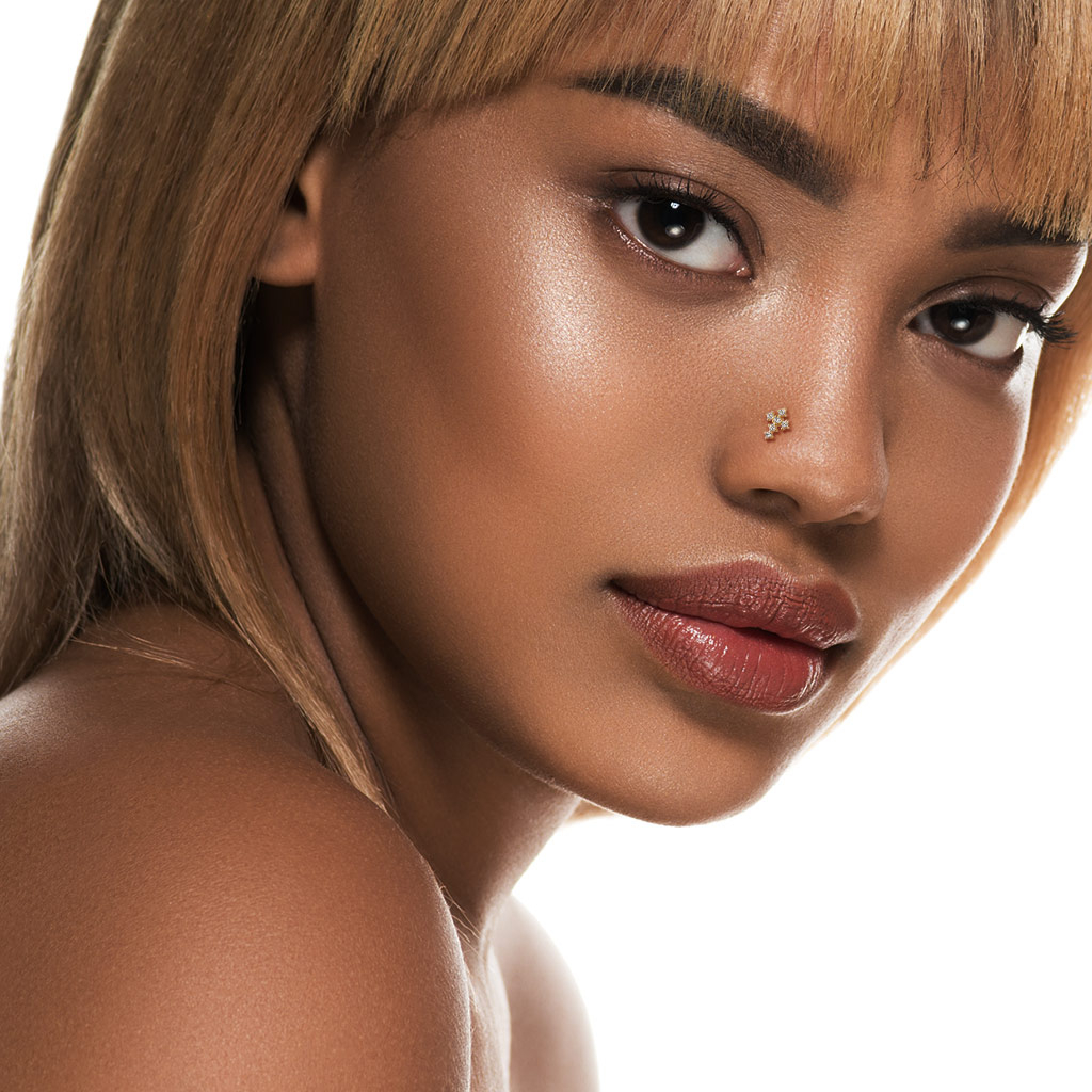 Näspiercing av 14 karat guld med kors av sten