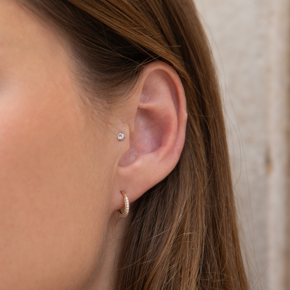 Ring av 14 kt guld med gångjärn och rund kant med CZ-stenar