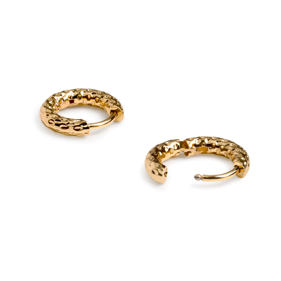 Ett par av huggie-örhängen med hamrad effekt