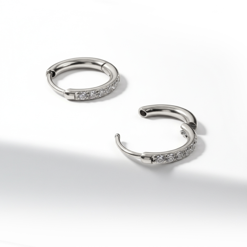 Ett par av huggieringar av kirurgiskt stål med stenar